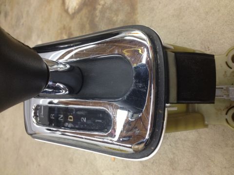 1998 Ford Crown Victoria - Top-down view of an automatic shifter's chrome gate bezel displaying the R N D 2 1 gear positions with leather boot.