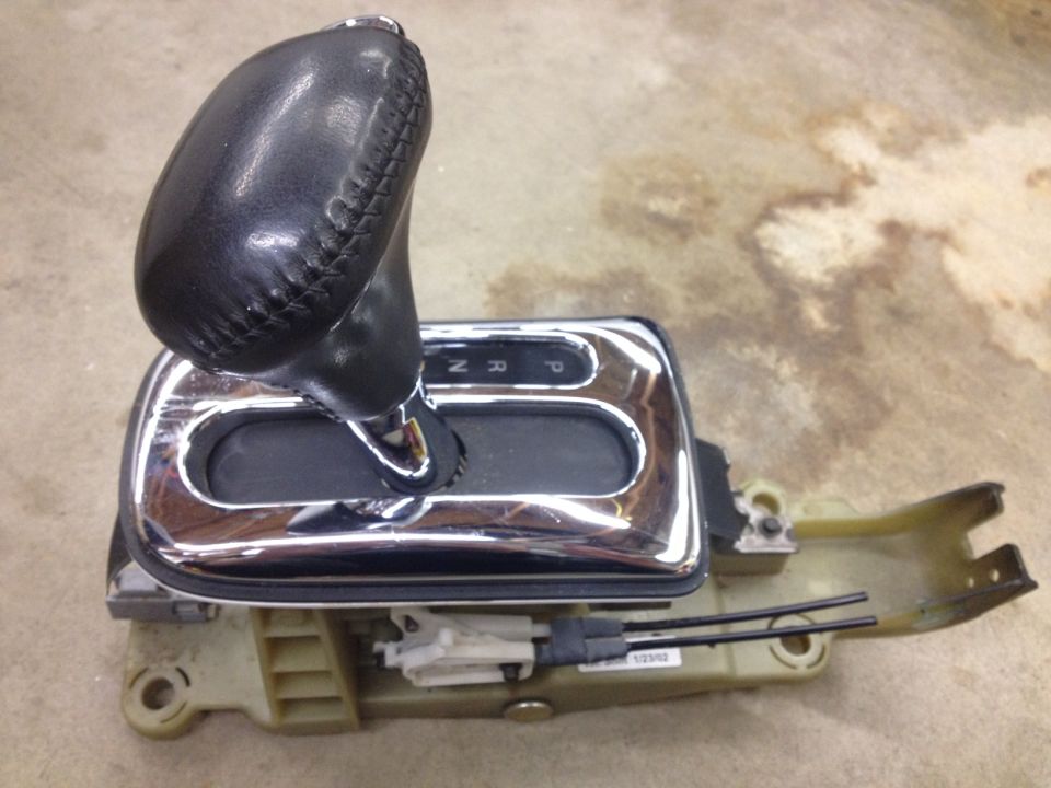 Side view of an automatic transmission shifter assembly with leather knob