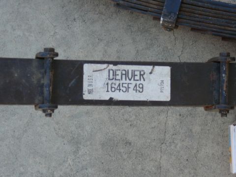 1988 Ford Bronco - A leaf spring with a part number is shown against a concrete surface.