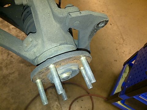 1995 Ford Probe - A close-up view of a vehicle's wheel hub assembly with exposed lug studs. The assembly appears to be made of cast metal and shows signs of…