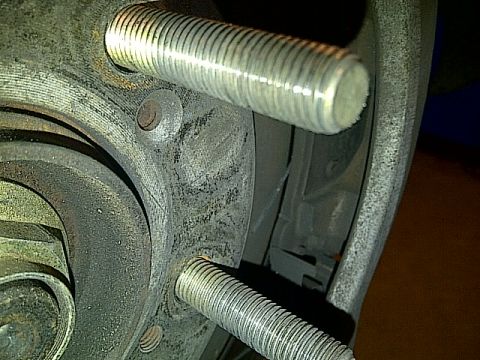 1995 Ford Probe - A close-up view shows two threaded metal studs protruding from a vehicle's hub assembly. The studs are silver and appear to be part of the…