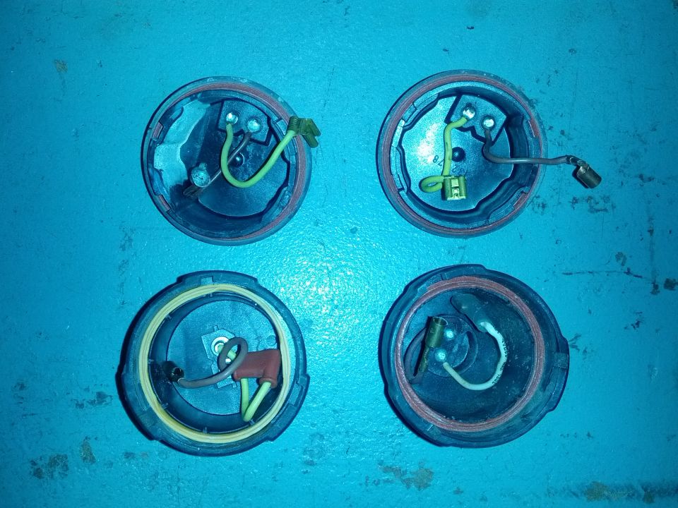 Four circular automotive electrical connectors with wires and terminals.