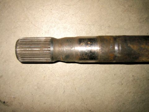 1985 Ford Bronco - A rusty splined metal shaft is shown against a concrete background.