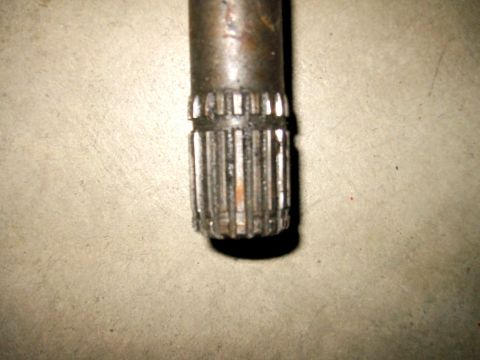 1985 Ford Bronco - A close-up view shows the splined end of a metal shaft against a textured surface.