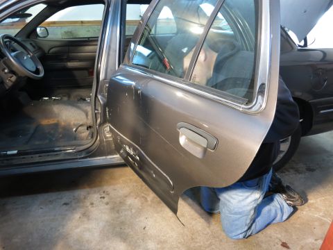 1991 Ford LTD Crown Victoria - Photograph of car door removal/repair work, not a document.