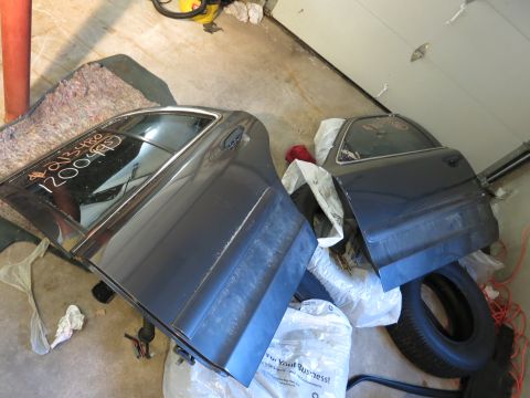 1991 Ford LTD Crown Victoria - Photograph of detached car doors stored in a garage, not a document.