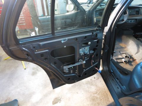 1991 Ford LTD Crown Victoria - Photograph of a car door with its trim panel removed, not a document.