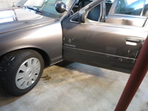 1991 Ford LTD Crown Victoria - Photograph of the side of a gray sedan in a garage, not a document.