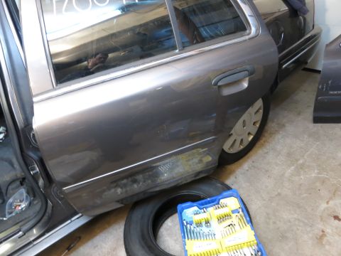 1991 Ford LTD Crown Victoria - Photograph of the side of a sedan in a garage, not a document.