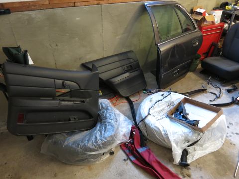 1991 Ford LTD Crown Victoria - Photograph of car door panels and parts arranged in a garage, not a document.