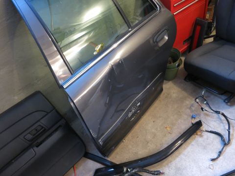 1991 Ford LTD Crown Victoria - Photograph of a removed dented rear door and wiring, not a technical document.