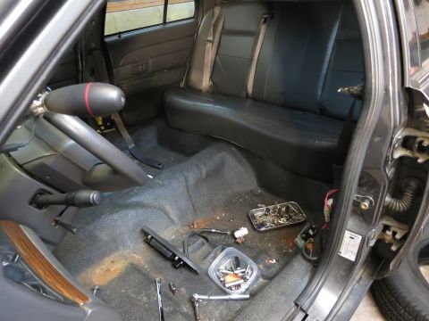 1991 Ford LTD Crown Victoria - Photograph of a sedan rear interior with parts and tools, not a technical document.