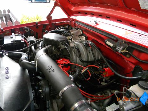 1995 Ford Bronco - The red engine bay of a 1995 Ford Bronco is shown, featuring a K&N air intake system, red spark plug wires, and a red distributor cap. The…