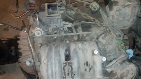 1988 Ford Bronco - This is a close-up, high-angle shot of a dirty, disassembled V8 engine, likely from a 1988 Ford Bronco. The intake manifold is prominently…