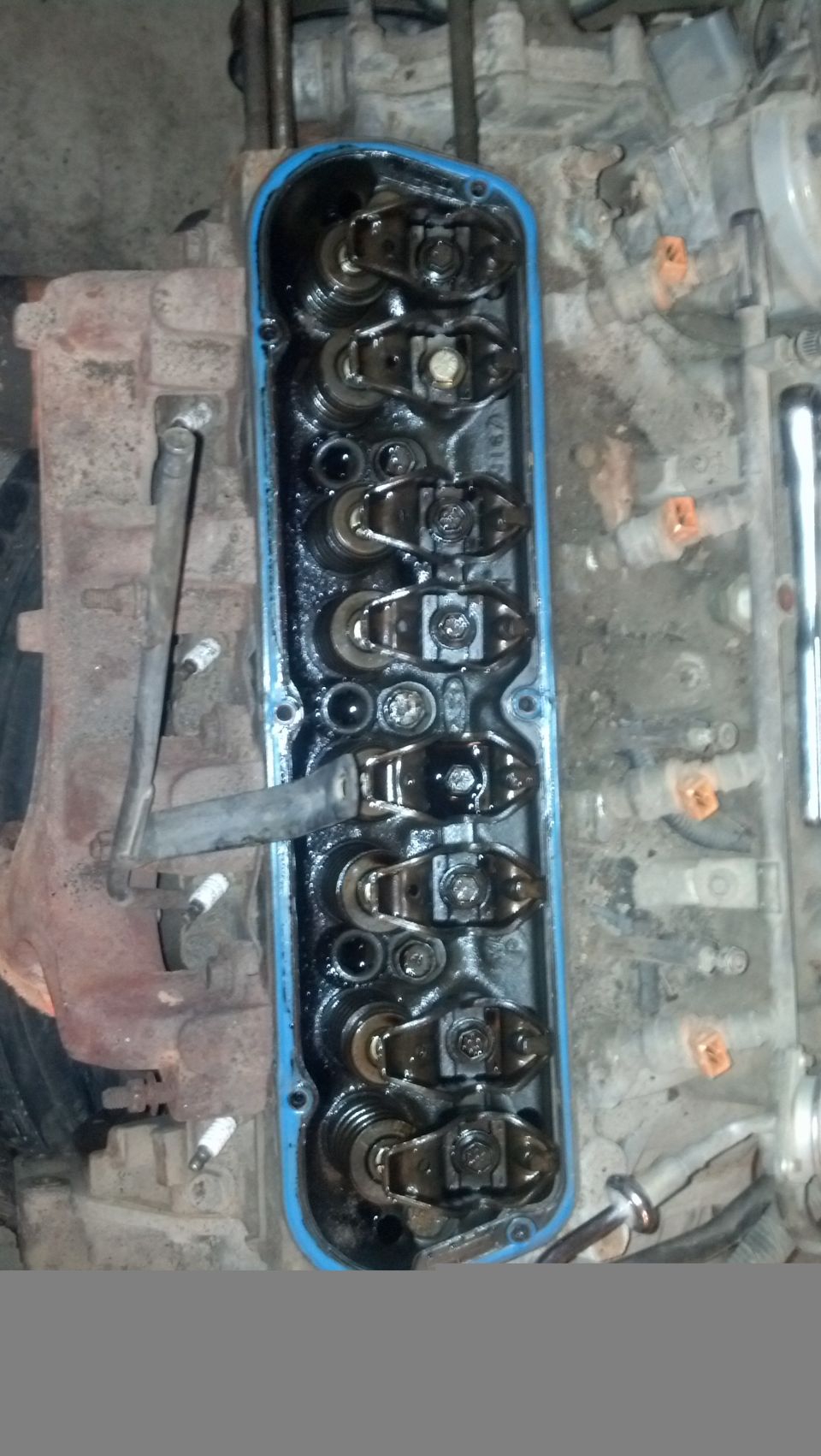 Top view of a V8 engine with valve cover removed, showing rocker arms and valve springs.