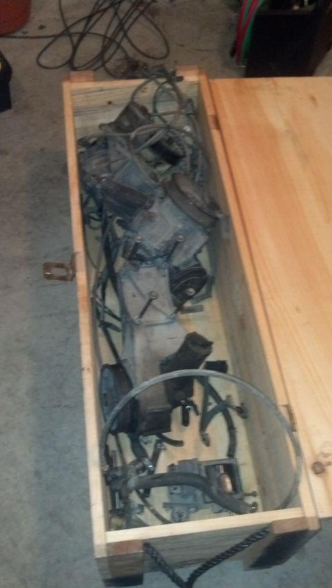 1988 Ford Bronco - A disassembled engine is packed inside a wooden crate. The engine components are dusty and appear to be from an older vehicle.