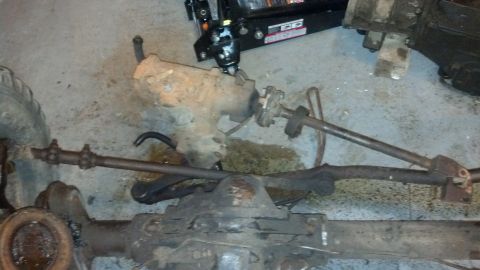 1988 Ford Bronco - Steering box and front axle components from a Ford Bronco are shown on the floor.