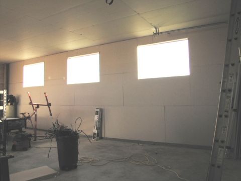 1995 Ford Bronco - This is an image of an unfinished room with drywall on the walls and ceiling. There are three windows that are brightly lit from the outsid…