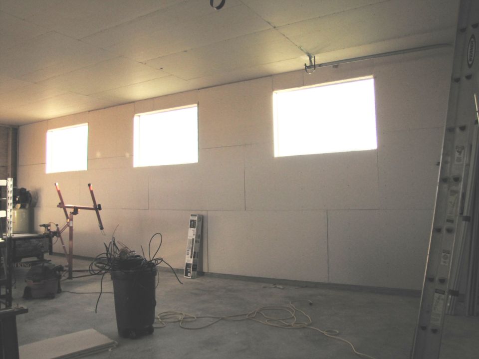Unfinished room with windows and construction materials