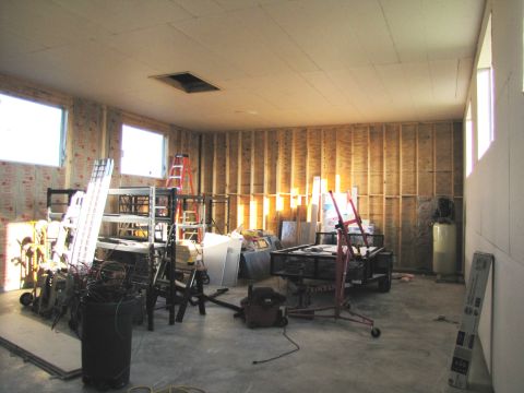 1995 Ford Bronco - The image shows an unfinished room with construction materials, tools, and equipment. There are windows, exposed wooden studs, and a concre…