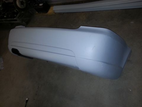 2002 Volkswagen Jetta - A white car bumper is shown on a workshop floor, ready for installation or repair.