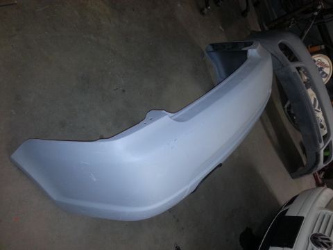 2002 Volkswagen Jetta - A car bumper is shown in primer, with another bumper visible in the background.