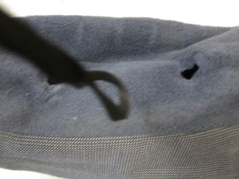 2001 Ford Crown Victoria - Close-up of damaged blue fabric with a black cord and visible holes.