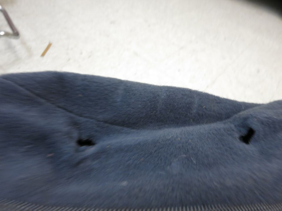 dark blue car seat fabric with two holes and some faint lines