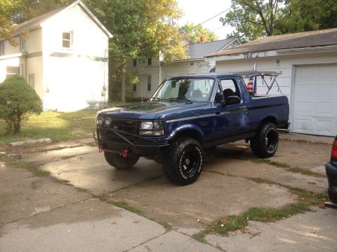 1996 Ford Bronco - This blue 1996 Ford Bronco is parked in a driveway next to a garage.