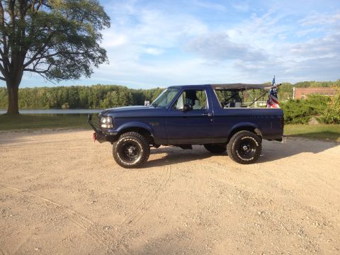 1996 Ford Bronco - This blue 1996 Ford Bronco features a removable soft top and an American flag mounted on the rear.