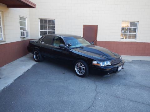 2003 Ford Crown Victoria - Photo of a black Mercury Grand Marquis sedan parked outside a building, not a technical document.