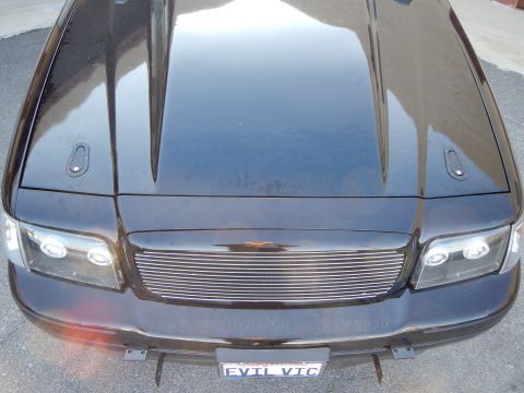 2003 Ford Crown Victoria - Photo of the hood, halo headlights and billet grille of a black 'EVIL VIC' Crown Victoria, not a technical document.