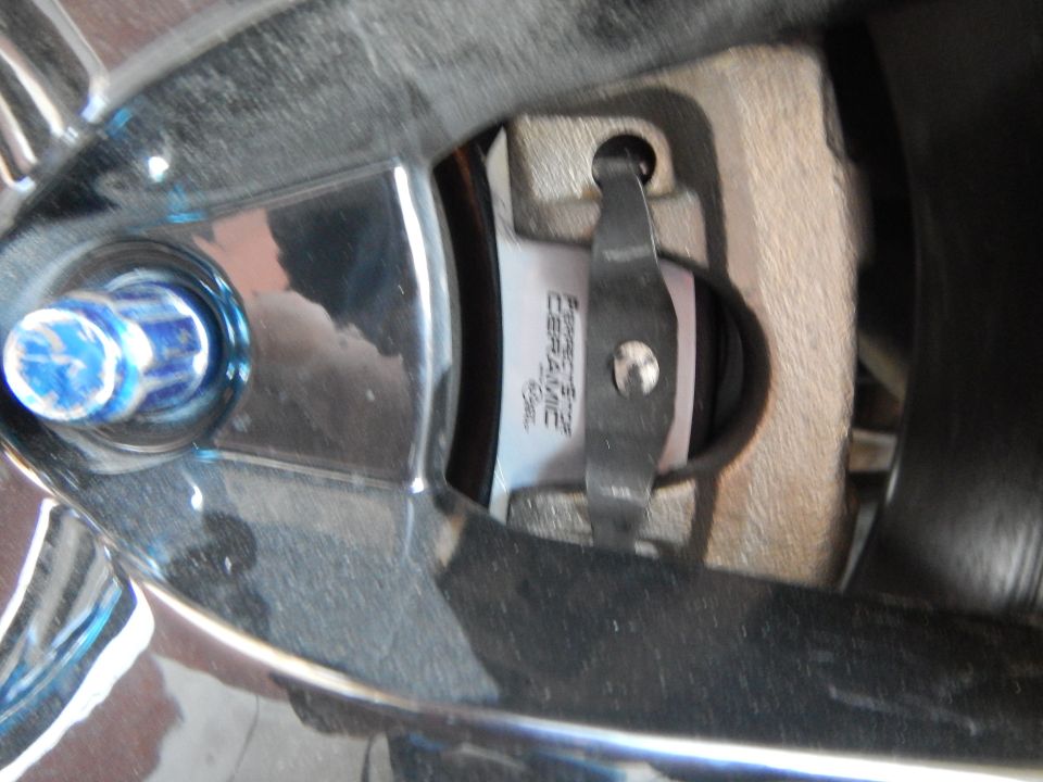 Brake pad stamped Perfect Stop Ceramic seated in caliper viewed through wheel spoke
