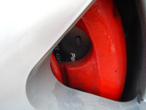 2003 Ford Crown Victoria - bright red painted brake caliper marked with PE and the number 4263, viewed through the opening of a silver wheel.