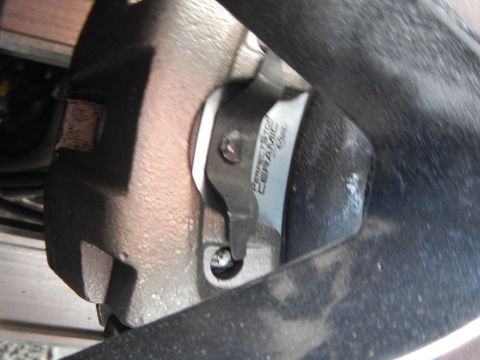 2003 Ford Crown Victoria - Perfect Stop Ceramic brake pad seated in its caliper, photographed at a steep angle behind a wheel.