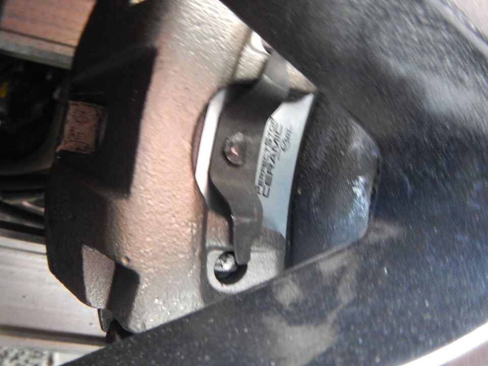 Perfect Stop Ceramic brake pad and caliper photographed at steep angle behind wheel
