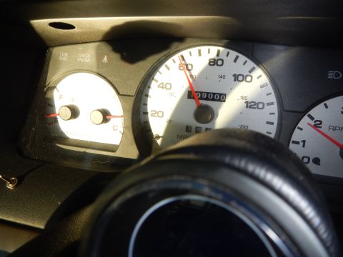 2003 Ford Crown Victoria - instrument cluster showing a Marauder-labeled speedometer, fuel gauge and tachometer, partly washed out by sunlight.