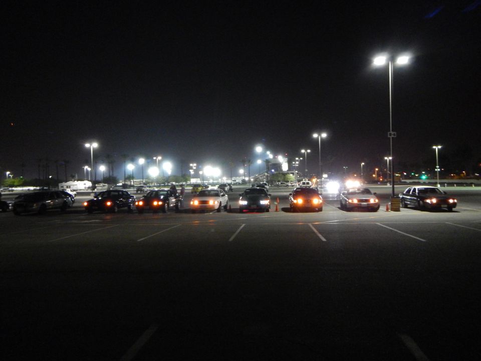 Cluster of sedans parked at angles in a night parking lot