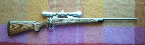 1995 Ford Bronco - Bolt-action rifle with scope on a plaid blanket.