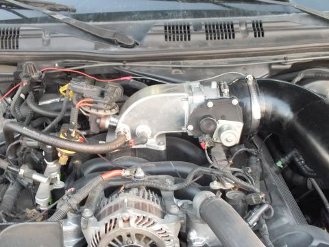 2003 Ford Crown Victoria - Engine bay close-up showing the intake manifold area, alternator, black intake tubing and a tangle of vacuum lines and wiring harness.