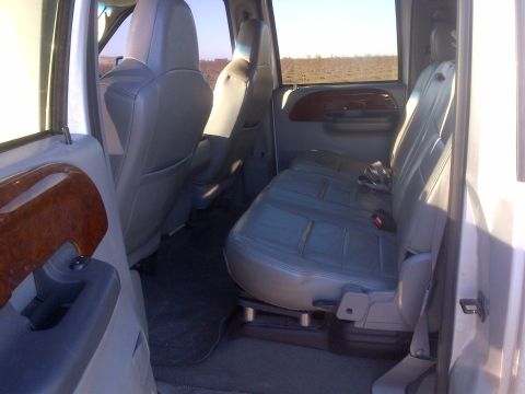 1985 Jeep CJ7 - The interior of a truck, leather seats and wood trim accents on the door panel.