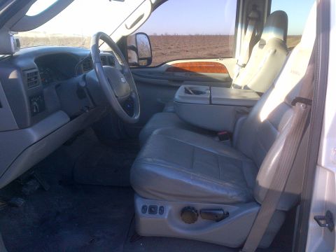 1985 Jeep CJ7 - The interior of a truck shows gray leather seats, dashboard, and steering wheel.