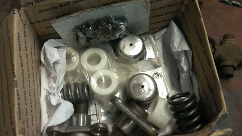 1995 Ford Bronco - A box contains various automotive parts, including springs and metal components, ready for installation or repair.