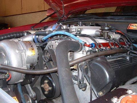 1992 Ford Crown Victoria - Close-up view of a modified engine bay a prominent supercharger and intricate plumbing.