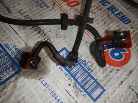 2003 Ford Crown Victoria - Photo of metal brake/fuel lines with bracket fittings laid on cardboard boxes.