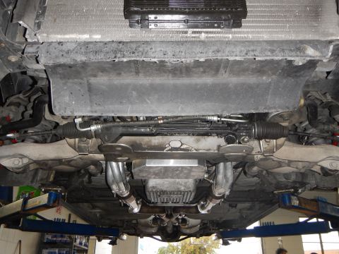 2003 Ford Crown Victoria - Photo of a vehicle underbody showing steering rack and exhaust headers on a shop lift.