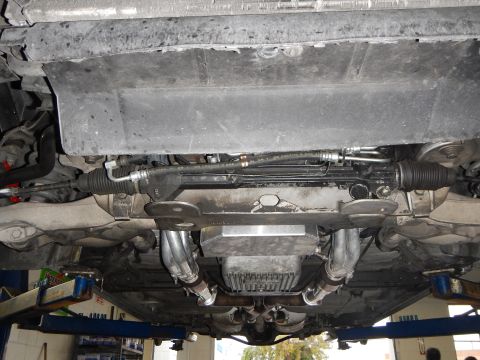 2003 Ford Crown Victoria - Photo of a vehicle underbody showing steering rack, headers and oil pan on a shop lift.