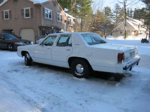 2001 Ford Crown Victoria - Photograph of a white Ford LTD Crown Victoria sedan in a snowy residential driveway, not a technical document.