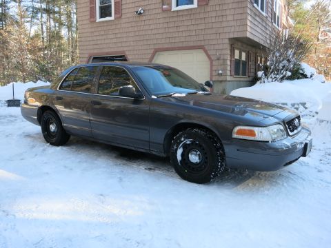 2001 Ford Crown Victoria - Photograph of a gray Ford Crown Victoria sedan in a snowy driveway, not a technical document.