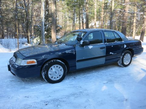 2001 Ford Crown Victoria - Photograph of a dark blue Ford Crown Victoria sedan parked in snow, not a technical document.